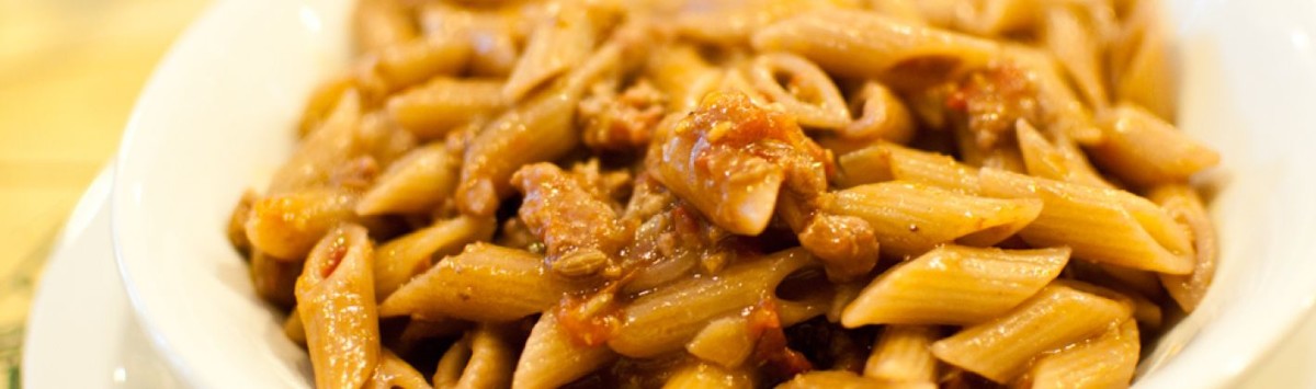 Pennette integrali con paté di olive, pomodorini e pan grattato